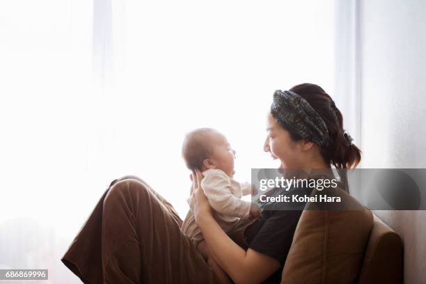 mother and baby relaxed at home - japanese mom stock-fotos und bilder