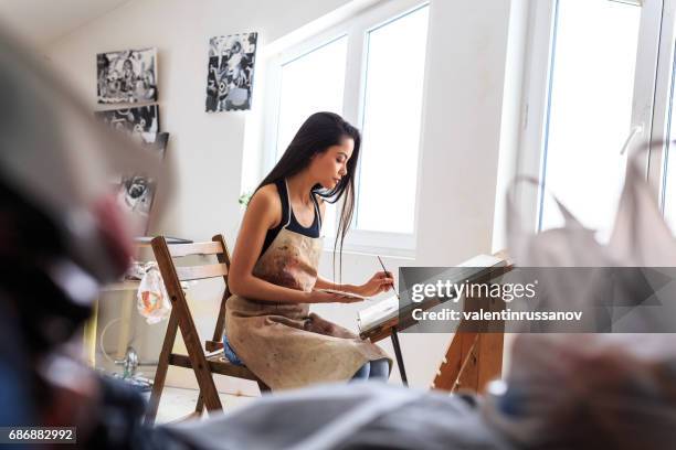 prifile view of female painter working in her studio - woman painting stock pictures, royalty-free photos & images