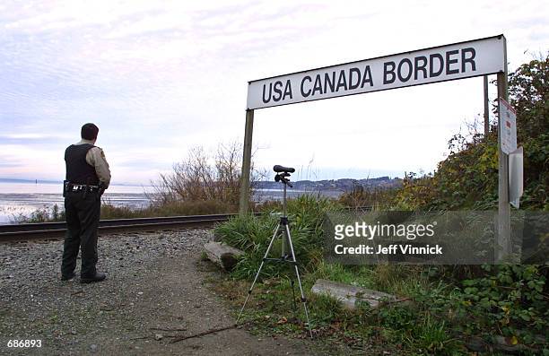 Canadian Customs and Fisheries officer watches over the U.S.-Canada border between Blaine, Washington and White Rock, British Columbia November 8,...