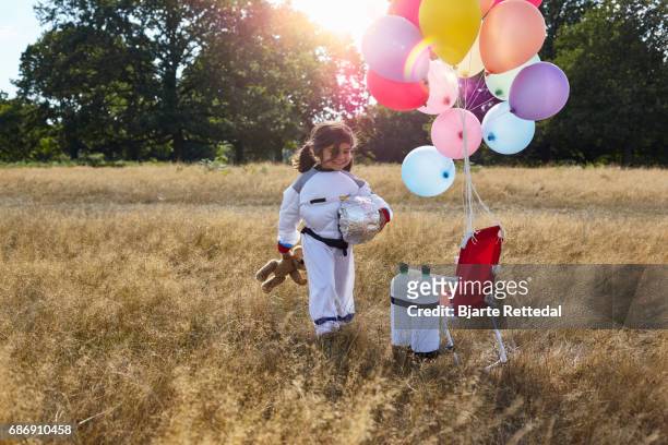girl in astronaut suit walking to her space ship - bjarte rettedal stock pictures, royalty-free photos & images
