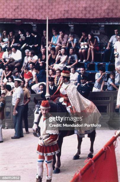 Palio di Siena. The Corteo Storico leading the horse race between the city wards parading on Piazza del Campo. Siena, 1975