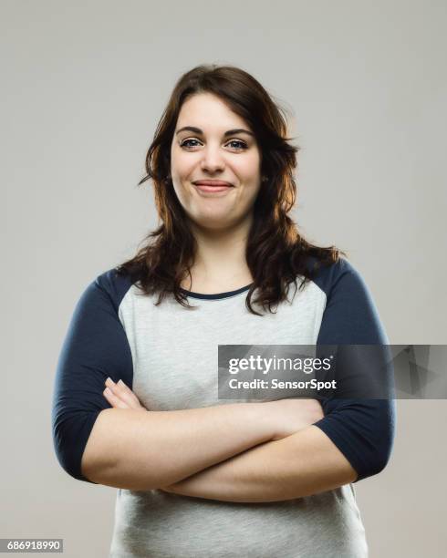 healthy young woman standing with her arms crossed - smirk stock pictures, royalty-free photos & images