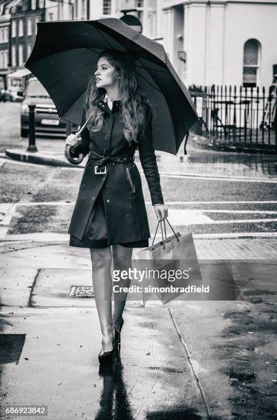 beautiful girl london street shopping bag - female fashion with umbrella stock pictures, royalty-free photos & images