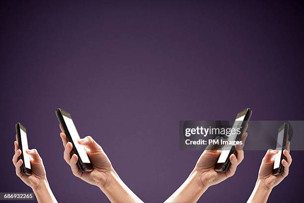 4 hands holding smart phones - facebook privacy stock pictures, royalty-free photos & images