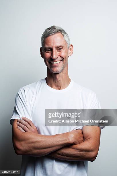 portrait of man in white t-shirt in his 50's - weiß stock-fotos und bilder