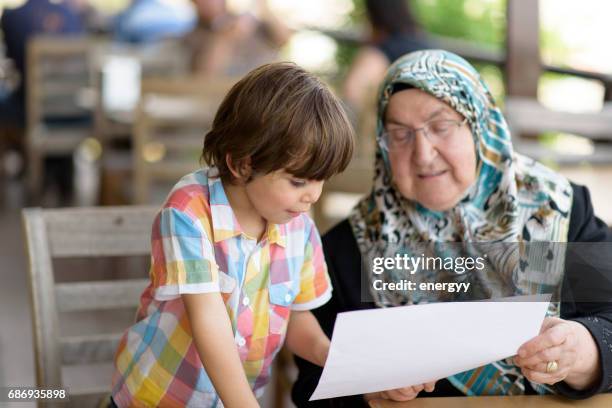 kleiner junge mit seiner großmutter - arab old woman stock-fotos und bilder