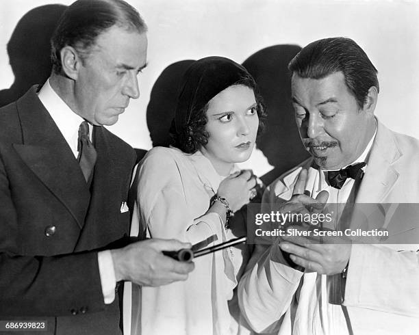 From left to right, actors Peter Gawthorne, Marguerite Churchill and Warner Oland in a publicity still from the film 'Charlie Chan Carries On', 1931.