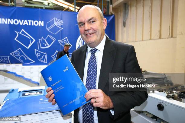 Finance Minister Steven Joyce poses with a copy of his budget speech during the printing of the budget at Printlink on May 23, 2017 in Wellington,...