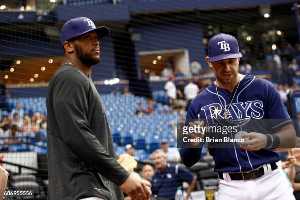 Howard of the Tampa Bay Buccaneers hands an autographed baseball to Evan Longoria of the Tampa Bay Rays moments before throwing out the ceremonial...
