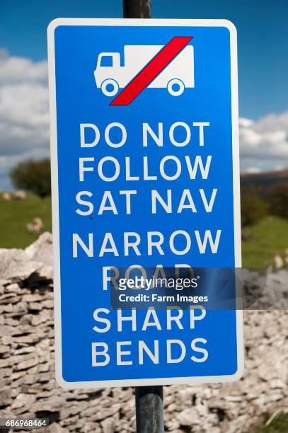 Signs on a narrow road warning wagons against following their Sat-Nav systems. Cumbria, UK.