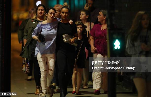 Police escort members of the public from the Manchester Arena on May 23, 2017 in Manchester, England. An explosion occurred at Manchester Arena as...