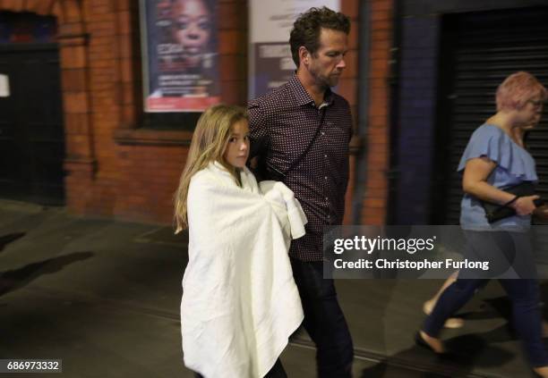 Police escort members of the public from the Manchester Arena on May 23, 2017 in Manchester, England. An explosion occurred at Manchester Arena as...