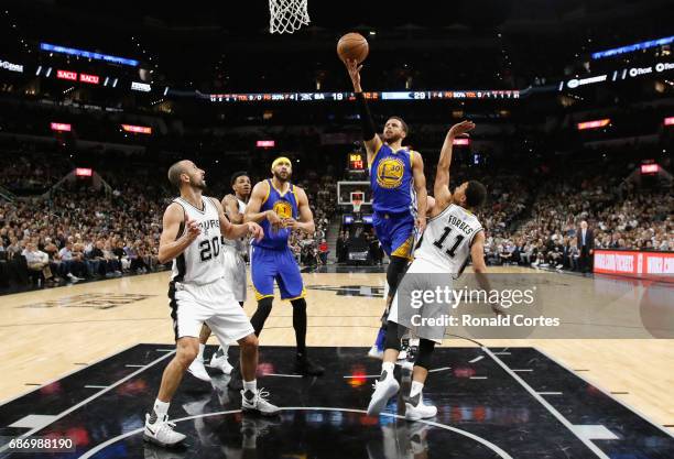Stephen Curry of the Golden State Warriors drives to the basket in the first half against Bryn Forbes of the San Antonio Spurs during Game Four of...
