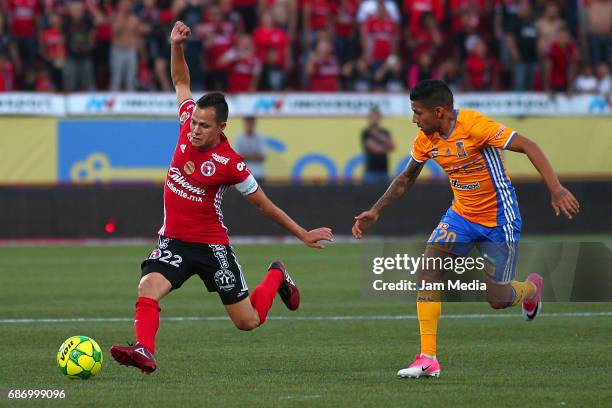 Juan Nuñez of Tijuana fights for the ball with Javier Aquino of Tigres during to the semi final second leg match between Tijuana and Tigres UANL as...