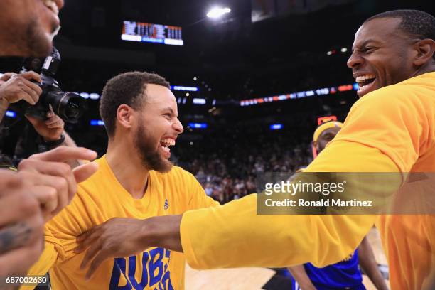 Stephen Curry of the Golden State Warriors celebrates with Andre Iguodala after defeating the San Antonio Spurs 129-115 in Game Four of the 2017 NBA...