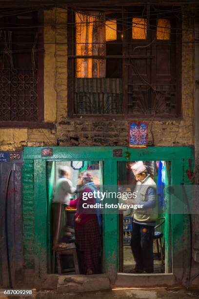 kathmandu night newar family in illuminated roadside restaurant nepal - nepal family stock pictures, royalty-free photos & images
