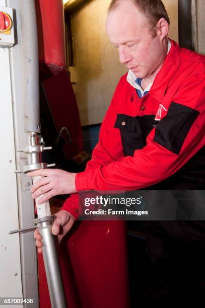 Farmer changing filter in milking line.