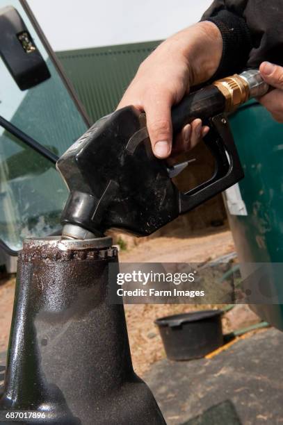 Farmer fueling tractor with red diesel.