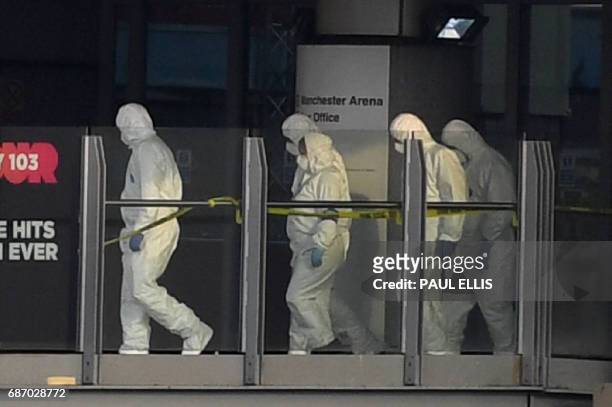 Police forensic officers walk along a bridge linking Victoria station to the Manchester Arena, scene of a terror attack during a pop concert by US...