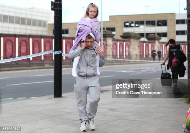 Man carries a young girl on his shoulders on May 23, 2017 in Manchester, England. An explosion occurred at Manchester Arena as concert goers were...