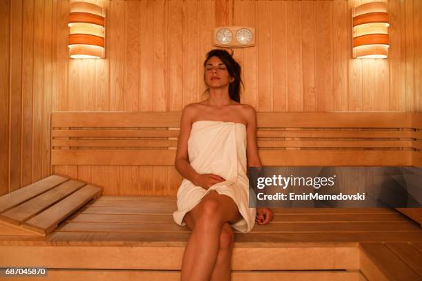 junge frau in sauna im wellnessbereich entspannen - sauna stock-fotos und bilder