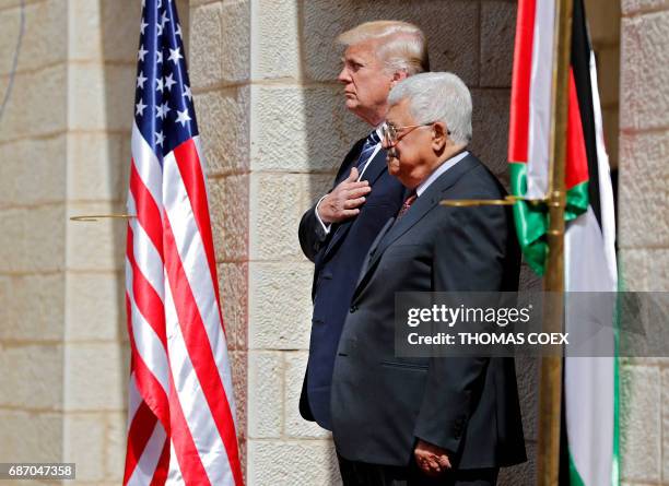 Palestinian Authority President Mahmud Abbas and US President Donald Trump listen to anthems during a welcome ceremony at the Presidential Palace in...