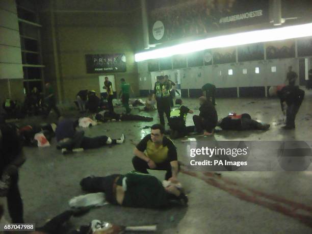 Helpers attend to people inside the Manchester Arena after a suspected suicide bomber detonated an explosive device at the end of an Ariana Grande...