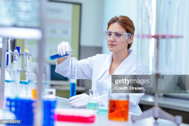 phd candidate in laboratory working with chemical solutions - liquid solution stock pictures, royalty-free photos & images