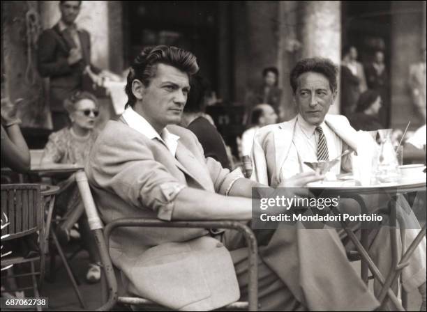 French actor Jean Marais and French writer and director Jean Cocteau s sitting at a caf table during the VIII Venice Film Festival. Venice, 1947