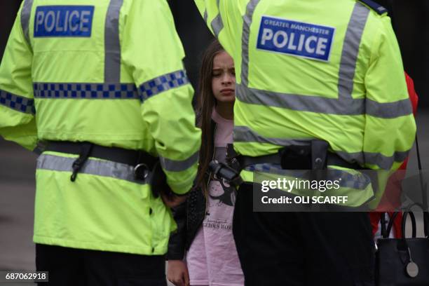 Woman and a young girl wearing a t-shirt of US singer Ariana Grande talks to police near Manchester Arena following a deadly terror attack in...