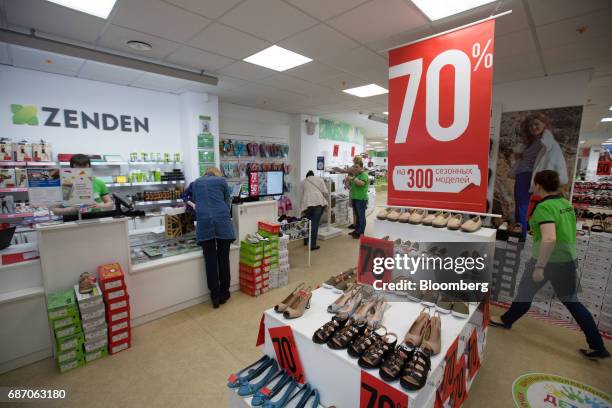 Customers browse discounted shoes inside a Zenden shoe store in Moscow, Russia, on Friday, May 19, 2017. The low-budget shoppers targeted...