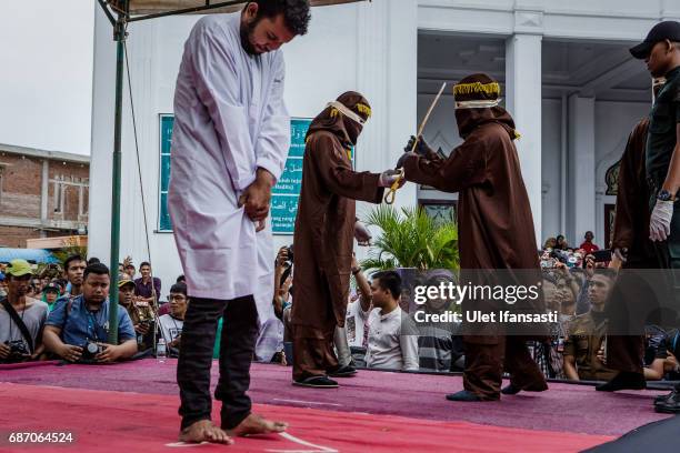 An indonesian man stands as prepare get caning in public from an executor known as 'algojo' for having gay sex, which is against Sharia law at...