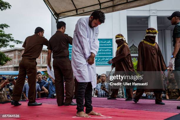 An indonesian man stands as prepare get caning in public from an executor known as 'algojo' for having gay sex, which is against Sharia law at...