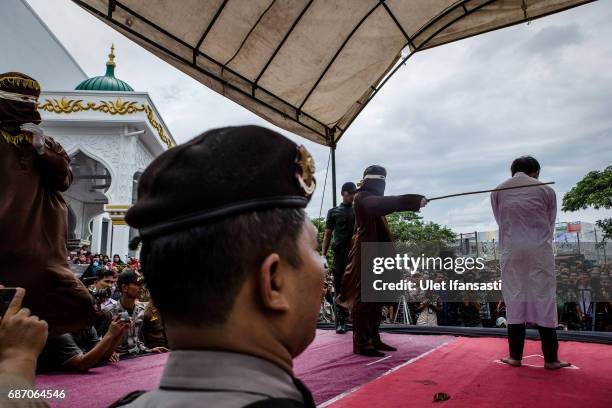An indonesian man gets caning in public from an executor known as 'algojo' for having gay sex, which is against Sharia law at Syuhada mosque on May...