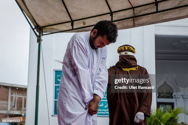 An Indonesian man gets caning in public from an executor known as 'algojo' for having gay sex, which is against Sharia law at Syuhada mosque on May...