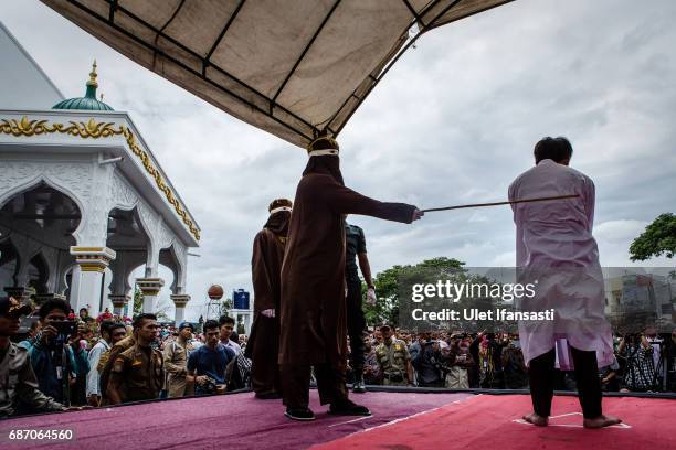 An Indonesian man gets caning in public from an executor known as 'algojo' for having gay sex, which is against Sharia law at Syuhada mosque on May...