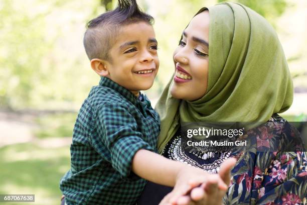 #muslimgirl and son dancing in the park - asian woman black shirt stock pictures, royalty-free photos & images