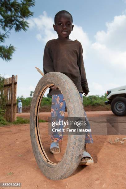 Children playing with a motorcycle tyre and a stick as a toy. Rwanda.