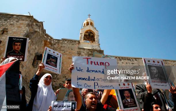 Palestinian protesters shout slogans and hold placards outside the Church of the Nativity in Bethlehem during a demonstration in support of prisoners...