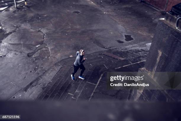 man jogging outdoors on a bad weather - zoom out effect stock pictures, royalty-free photos & images