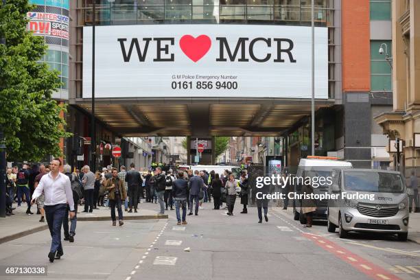 Crowds of people wait outside after police avacuated the Arndale Centre on May 23, 2017 in Manchester, England. An explosion occurred at Manchester...