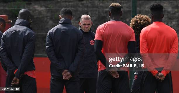 Manchester United's English striker Wayne Rooney stands with teammates as they observe a minute's silence for the victims of yesterday's terror...