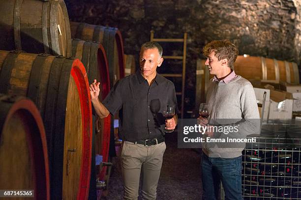 two men wine tasting in a cellar - wine barrel stock pictures, royalty-free photos & images