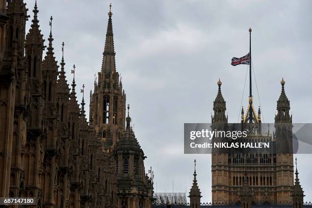 Union flag flies at half-mast from a flagpole above the Houses of Parliament in London on May 23 as a mark of respect to those killed and injured in...