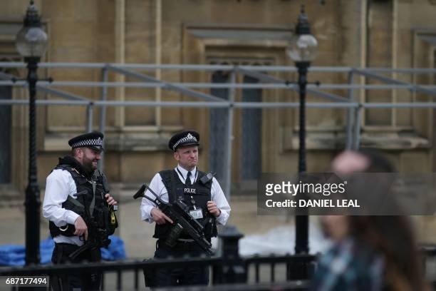 Armed British Police officers stand on duty outside of the Houses of Parliament in Westminster, central London on May 23 following the terror attack...