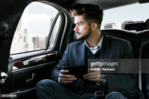 businessman getting data on tablet device - limo driver stock pictures, royalty-free photos & images
