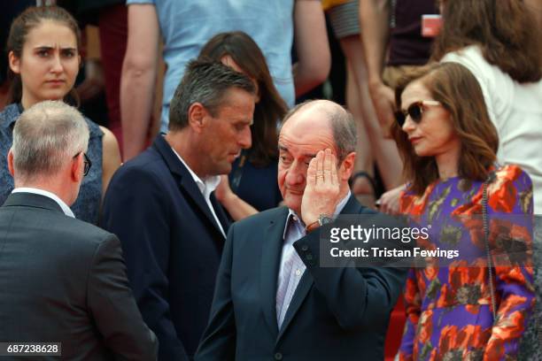Isabelle Huppert looks on as President of the Cannes Film Festival Pierre Lescure puts his hand to his head before a minute of silence is held for...