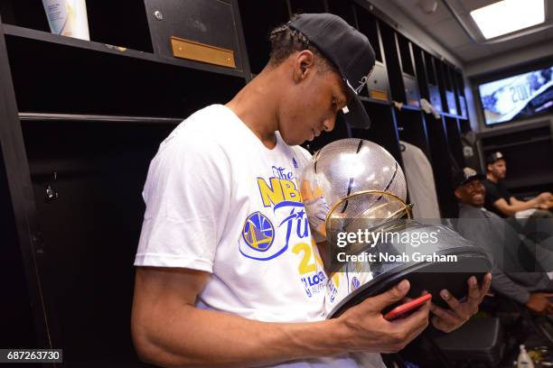 Patrick McCaw of the Golden State Warriors holds the Western Conference Championship Trophy after winning Game Four of the Western Conference Finals...