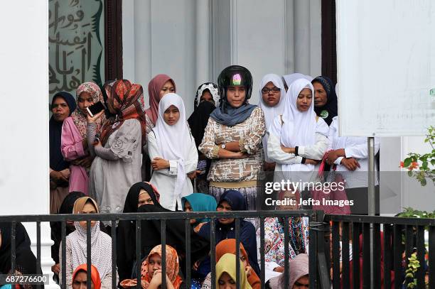 Acehnese watch the being whipped in public for violating sharia law on May 23, 2017 in Banda Aceh, Indonesia. About four Acehnese couple received 25...