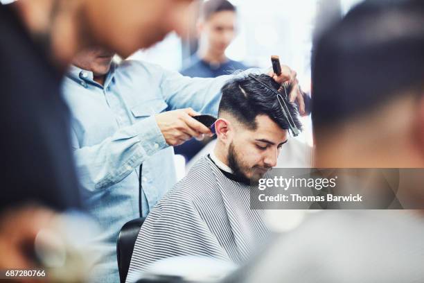 man having hair cut in barber shop - barber shop interior stock pictures, royalty-free photos & images